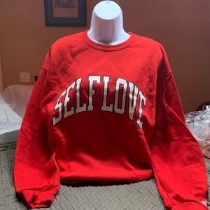 A crewneck that says self-love on it